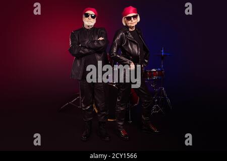 Full size photo of two pensioners family cool aged lady man rock group all life on stage concert show drum instruments behind wear trendy rocker Stock Photo