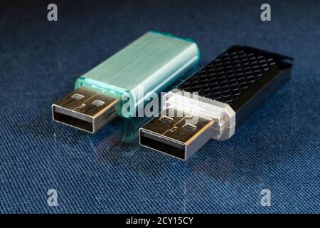 USB drive rests upon turn blue the glass table. Disk for keeping of information Stock Photo