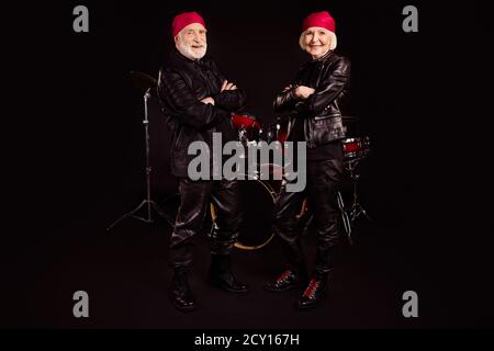 Full size photo of two pensioners cool aged lady man rock group performing all life together concert drum instruments behind wear trendy rocker Stock Photo