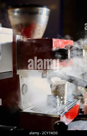 The prepares espresso in his coffee shop. Shallow dof. Stock Photo