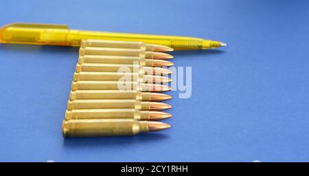 Military Cartridges  5.56mm Ammunition With a Pen as a Concept of Propaganda in Mass Media. Fake News Invasion Concept. Ukraine Crisis. Syria War. Stock Photo