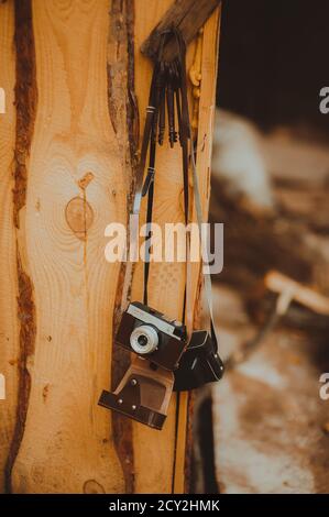 Close up old vintage retro cameras hanging on a wooden board. Stock Photo