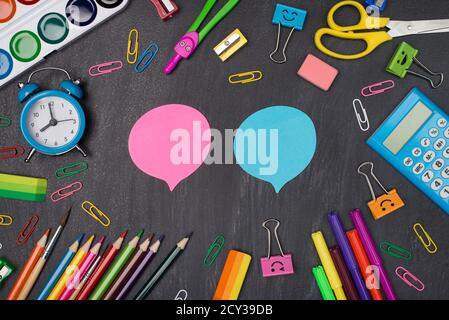 Giving comments and opinion concept. Top above overhead view photo of colorful stationery around two pink and blue bubbles isolated on blackboard Stock Photo