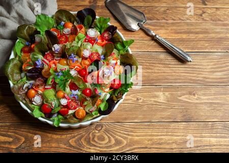 Low-calorie cold pie with fresh vegetables and soft cheese in a bowl and silver spatula on a wooden background Stock Photo