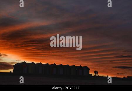 The sun sets behind the beach huts in Blyth, Northumberland. Stock Photo