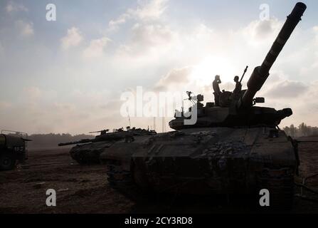 Israeli soldiers stand atop a tank, just outside the Gaza Strip July 22, 2014. Israel pounded targets across the Gaza Strip on Tuesday, saying no ceasefire was near as top U.S. and United Nations diplomats pursued talks on halting the fighting that has claimed more than 600 lives. With the conflict entering its third week, the Palestinian death toll rose to 613, including nearly 100 children and many other civilians, Gaza health officials said. Israel's casualties also mounted, with the military announcing the deaths of two more soldiers, bringing the number of army fatalities to 27 - almost t