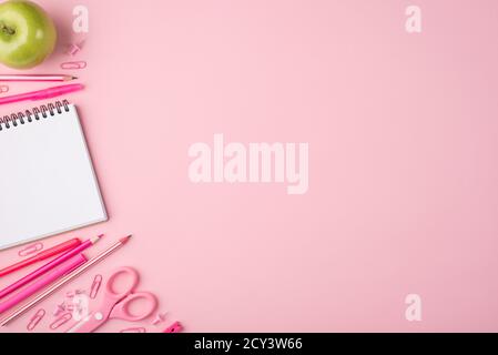 Back to school concept. Top above overhead view photo composition of apple and colorful stationery isolated on pastel pink background with copyspace Stock Photo