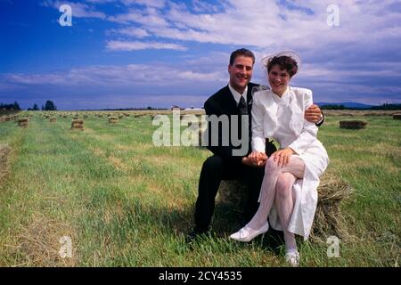 1990s NEWLYWED MAN WOMAN BRIDE GROOM HUSBAND WIFE SITTING HUGGING LOOKING AT CAMERA IN HAYFIELD IN EASTERN WASHINGTON STATE USA - kb31149 LGA001 HARS SPRING COLOR RELATIONSHIP GROOM TOUCHING OLD TIME FUTURE NOSTALGIA HUGGING OLD FASHION 1 YOUNG ADULT HAY EMBRACE TOUCH STRONG ABSTRACT JOY LIFESTYLE CELEBRATION FEMALES MARRIED RURAL SPOUSE HUSBANDS HEALTHINESS HOME LIFE HORIZONTAL COPY SPACE FRIENDSHIP FULL-LENGTH HUG LADIES MARRIAGE PERSONS INSPIRATION CARING FARMING MALES CONFIDENCE CEREMONY EMBRACING HUSBAND AND WIFE PARTNER EYE CONTACT CELEBRATE PEOPLE STORY DREAMS HAPPINESS FARM CROP AND Stock Photo