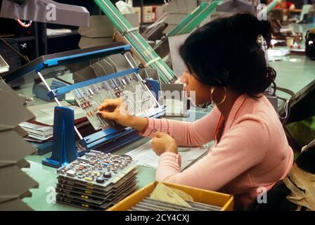 1970s SINGLE AFRICAN-AMERICAN WOMAN WORKER ASSEMBLING COMPUTER CIRCUIT BOARD IN FACTORY IN PENNSYLVANIA USA - ki4088 HAR001 HARS HEALTHINESS UNITED STATES HALF-LENGTH LADIES COMPUTERS PERSONS UNITED STATES OF AMERICA PROFESSION NORTH AMERICA NORTH AMERICAN SKILL OCCUPATION SKILLS WELLNESS HEAD AND SHOULDERS AFRICAN-AMERICANS AFRICAN-AMERICAN CAREERS PA ASSEMBLING BLACK ETHNICITY LABOR PRIDE IN EMPLOYMENT OCCUPATIONS HIGH TECH CONCEPTUAL EMPLOYEE CIRCUIT PRECISION YOUNG ADULT WOMAN COMPUTING HAR001 LABORING OLD FASHIONED AFRICAN AMERICANS Stock Photo