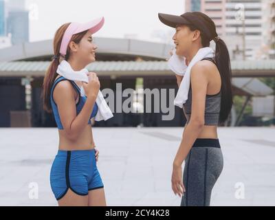 Two healthy woman runners in sportswear talking in city background after running exercise in the morning. Concept of women fitness and lifestyle. Stock Photo