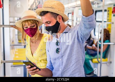 Beautiful couple driving on a subway wagon during covid-19 pandemic, concepts about lifestyle, trasportation and social distancing Stock Photo