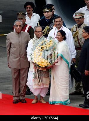 India's President Pranab Mukherjee (C) is greeted by West Bengal state Chief Minister Mamata Banerjee (3rd R) during his first visit to the state as the country's president, at the Netaji Subhas Chandra Bose International Airport in Kolkata September 14, 2012. REUTERS/Rupak De Chowdhuri (INDIA - Tags: POLITICS)