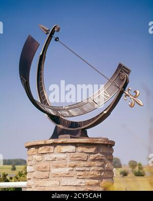 1960s SUNDIAL OUTDOOR ON STONE PEDESTAL ON BRIGHT SUNNY DAY CAST SHADOW OF ARROW POINTER INDICATES TIME 3 O’CLOCK IN AFTERNOON - ks5210 HAR001 HARS OLD FASHIONED REPRESENTATION Stock Photo