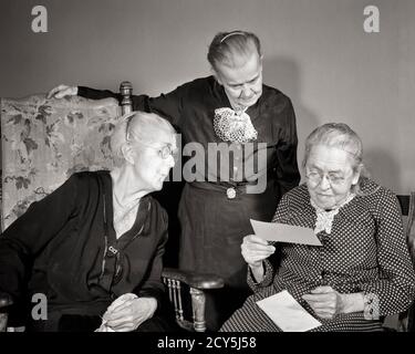 1930s 1940s THREE ELDERLY SENIOR GRAY HAIR WOMEN READING OVER SHOULDER RECEIVED MAIL LETTER CHECK IN OLD AGE RETIREMENT HOME  - s2562 HAR001 HARS INFORMATION FAMILIES JOY LIFESTYLE ELDER FEMALES HEALTHINESS HOME LIFE COPY SPACE FRIENDSHIP HALF-LENGTH LADIES PERSONS WISE CARING RETIREMENT SIBLINGS SISTERS SENIOR ADULT B&W SENIOR WOMAN OLD AGE WELLNESS OLDSTERS OLDSTER STRENGTH WISDOM COURAGE EXCITEMENT IN SIBLING ELDERS SURVIVORS CONCEPTUAL STYLISH COOPERATION ELDERLY WOMAN GRAY GRAY HAIR RECEIVED TOGETHERNESS BLACK AND WHITE CAUCASIAN ETHNICITY HAR001 OLD FASHIONED Stock Photo