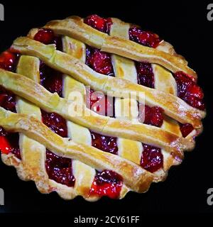 cherry filled pie in close up with black background Stock Photo