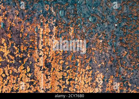 Grungy rusty metal wall with cracked orange paint Stock Photo