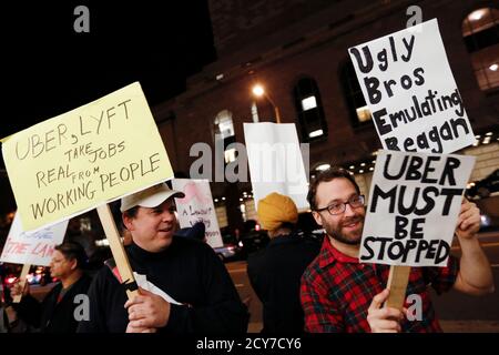 Demonstrators hold signs during a protest organized by the San Francisco Taxi Workers Alliance against ridesharing services Uber and Lyft outside the 8th Annual Crunchies Awards in San Francisco, California February 5, 2015. App-based ride service Uber, and smaller rival Lyft, face separate lawsuits seeking class action status in San Francisco federal court, brought on behalf of drivers who contend they are employees and entitled to reimbursement for expenses, including gas and vehicle maintenance. The drivers currently pay those costs themselves.  REUTERS/Stephen Lam (UNITED STATES - Tags: TR