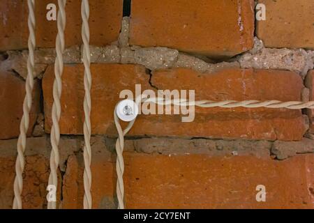 retro old design imitation of electric fuses with electric wires on a red brick wall background Stock Photo