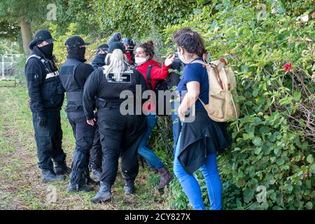 Wendover, UK. 1st October, 2020. A lightweight member of the press filming the events today is forcibly shoved by a big female NET Enforcement Agent. Peaceful tree protectors and environmental campaigners at the Stop HS2 Jones Hill Protection Camp were being evicted today from their homes in the trees by the National Eviction Team Enforcement Agents working on behalf of HS2 Ltd. The over budget and controversial HS2 High Speed Rail link from London to Birmingham project puts 108 ancient woodlands, 693 wildlife sites and 33 SSSIs at risk of damage or destruction. Maureen McLean/Alamy Live News Stock Photo