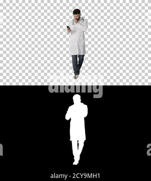 Male doctor in white medical uniform walking and using smartphon Stock Photo