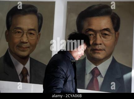 A man walks past portraits of China's President Hu Jintao (R) and Premier Wen Jiabao by Chinese artist Ye Zhifu outside a gallery in Beijing, January 18, 2011. Hu arrives in the United States on Tuesday for a four-day visit, with the centerpiece of the trip a formal state visit on Jan. 19 at the White House. REUTERS/Jason Lee(CHINA - Tags: POLITICS)