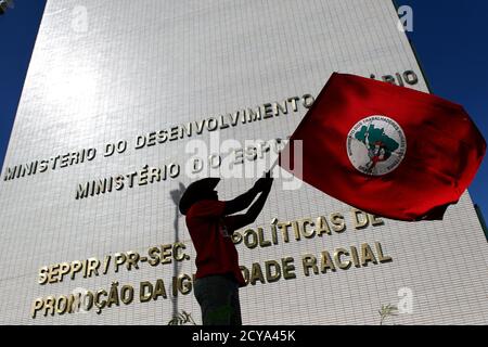 A member of the Landless Movement (MST) waves a flag near the Ministry of Agrarian Development to demand an audience with Brazil's President Dilma Rousseff in Brasilia April 16, 2012. The protesters were marking the 16th anniversary of the Eldorado dos Carajas massacre where 19 landless workers were killed.   REUTERS/Ueslei Marcelino (BRAZIL - Tags: CIVIL UNREST POLITICS)
