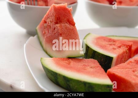 Water melon slices close up on a plate on white background Stock Photo