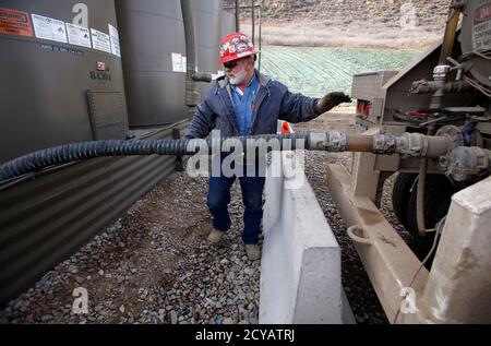 Lee White pumps water from a natural gas well platform owned by Encana south of Parachute, Colorado, December 8, 2014. The economy of Parachute, with a current population of approximately 1000 people, was devastated when thousands of workers lost their jobs on 'Black Sunday' in 1982, after Exxon terminated the Colony Shale Oil Project. The current rise of hydraulic fracking in natural gas retrieval has given a cautious hope to the town's inhabitants, who know market demand and price can effect their local economy.  Reuters/Jim Urquhart (UNITED STATES  - Tags: ENERGY BUSINESS EMPLOYMENT)