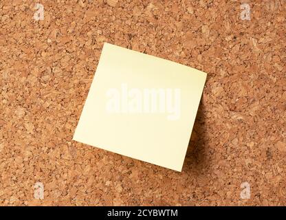 Yellow sticky note on corkboard Stock Photo