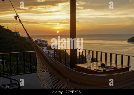 Perfect Sunset over the Caribbean Sea from the balcony with a hammock in the touristic village of Taganga near Santa Marta, Stock Photo