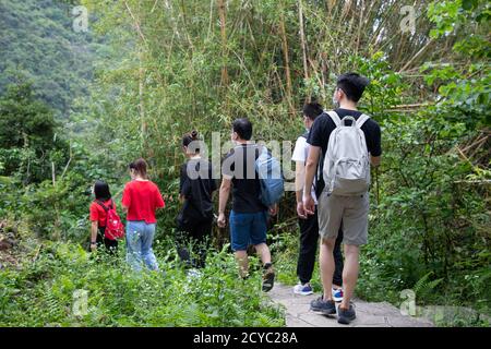 young men, women or boys and girls, university students with face masks hiking along trails in Victoria Peak, Hong Kong during covid-19 Stock Photo