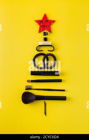 Beautiful Christmas tree made of makeup artist items on a colored background. New year 2021 Stock Photo