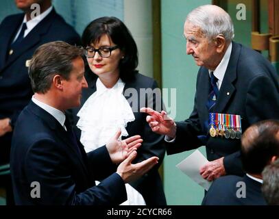 British Prime Minister David Cameron (L) talks to Australian World War Two veteran Murray Maxton in Australia's House of Representatives chamber at Parliament House in Canberra November 14, 2014. Cameron, who had just finished addressing both houses of parliament, met Maxton and his brother Eric (not shown) who served in the same bomber crew of 460 Squadron during the World War Two. REUTERS/David Gray (AUSTRALIA - Tags: POLITICS)