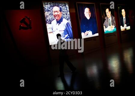 A man walks past portraits of Chinese leaders Mao Zedong (L-R), Deng Xiaoping, Jiang Zemin and Hu Jintao at the Revolution museum in Jinggangshan, Jiangxi province, September 20, 2012. China has yet to announce the start date for the 18th Communist Party Congress, China's biggest political meeting in 10 years, which will see the transfer of power from President Hu Jintao and Premier Wen Jiabao to a new generation. REUTERS/Carlos Barria  (CHINA - Tags: POLITICS)
