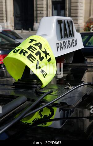 A yellow ribbon indicates a striking Paris taxi which takes part in a demonstration in the French capital June 11, 2014. Paris commuters faced gridlock getting into the city on Wednesday morning when taxis slowed traffic on major arteries into the centre. Taxi drivers across Europe say applications of companies like San Francisco-based Uber Technologies Inc. are breaking local taxi rules across the European Union and threatening their livelihoods.  REUTERS/Philippe Wojazer   (FRANCE - Tags: BUSINESS TRANSPORT EMPLOYMENT)