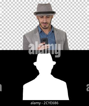 Smart casual arabian man using smartphone while walking, Alpha C Stock Photo