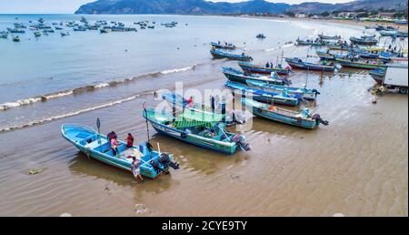 Puerto Lopez, Ecuador - September 12, 2018 - drone aerial view of beach with fishing boats on the sand at the end of the work day Stock Photo