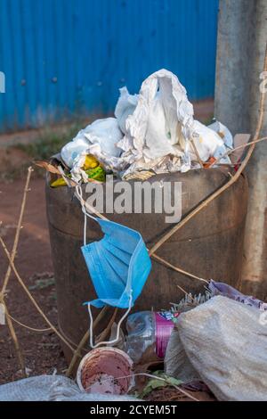 used face mask thrown in the trash bin Stock Photo