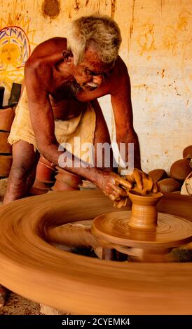 Madurai, India, Mar 10, 2018 - Man forms bowl on a manual pottery wheel with no electricity Stock Photo