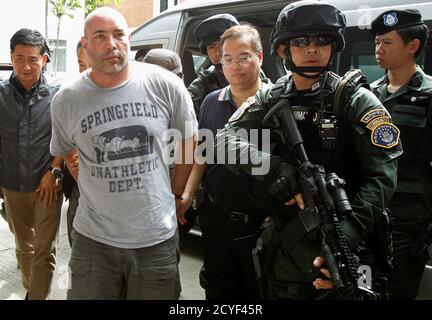 Thai policemen escort an American drug suspect Joseph Hunter, 48, as he arrives at Don Mueang International Airport in Bangkok September 27, 2013. Thai police transferred six foreigners suspected of drug smuggling to Bangkok on Thursday after their arrests in the seaside resort, Phuket. Hunter, along with two British, a Taiwanese, a Slovak, and a Filipino were arrested on Phuket island on Wednesday following a tip-off from the United States Drug Enforcement Administration (DEA). REUTERS/Chaiwat Subprasom (THAILAND - Tags: CRIME LAW DRUGS SOCIETY)