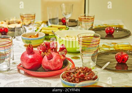 Festively decorated table for Rosh Hashanah, with pomegranates and apples. Close up Stock Photo