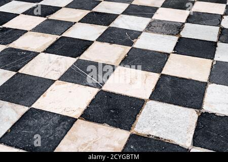 Black and white checkerboard tiles, old with scratches and scuffs. Stock Photo