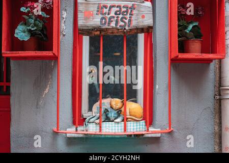 23.12.2019, Istanbul, Turkey. Decorative figure of two sleeping cats located behind the red bars at the window. Old streets of Istanbul, Turkey. The c Stock Photo