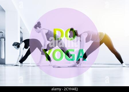 A group of young women doing yoga in the classroom. The concept of sports lifestyle, health and yoga practice. Text DO YOGA. Stock Photo