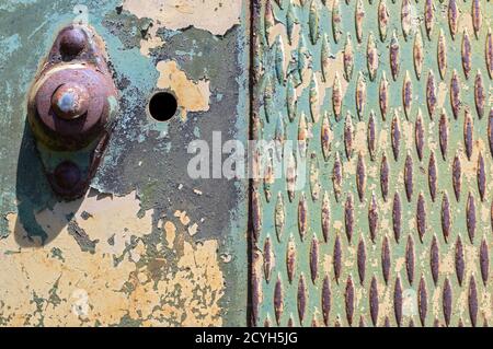 Paint peeling on a metal plate with non slip grating pattern Stock Photo