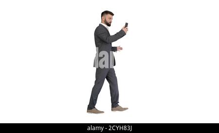 Handsome businessman walking and recording vlog on his phone on Stock Photo
