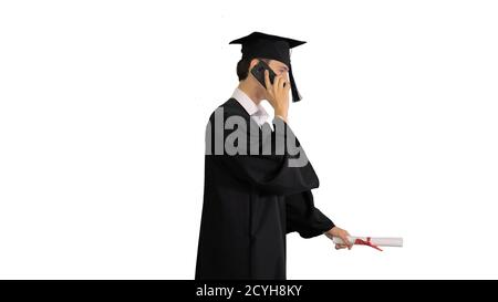 Graduating student starts walking and making a call on white bac Stock Photo