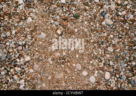 Background Sea pebbles and sand on the beach, texture close-up. Stock Photo