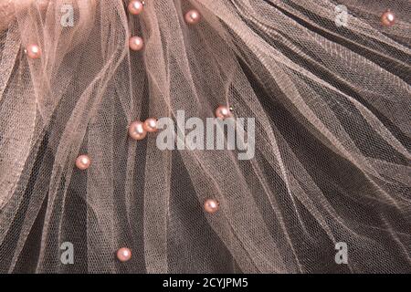 Beautiful transparent pink tulle with shiny beads background. Draped background of pink powdery fabric, texture. Copy space Stock Photo