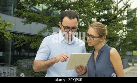 Young and smart business people standing outside the office. The Stock Photo